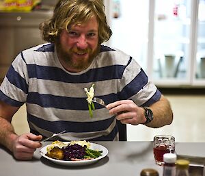 Tim eating dinner with a smile