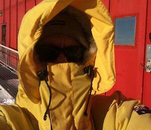 Jukka wearing a winter goose jacket, his face hidden by hood — taken outside of Casey station