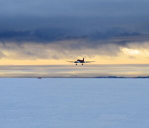 Aircraft on final approach with low clouds in the background