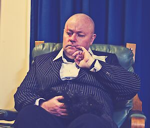 Scotty as Blofeld, wearing a black pin strip suit with a black feather duster as a pretend cat