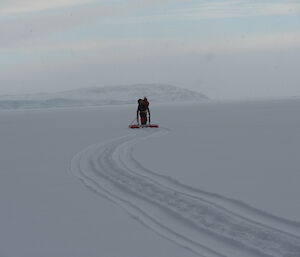 SAR member on the floating pod. A trail from the pods floats on the snow