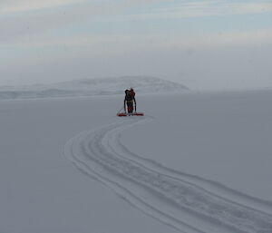 SAR member on the floating pod. A trail from the pods floats on the snow