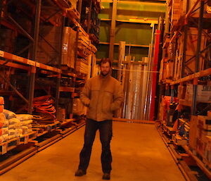 Aaron standing in between two green store racks