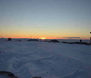 Sunset over Wilkes. Tops of old structures exposed from snow covered terrain