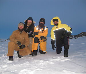 Four expeditioners posing outside on the snow