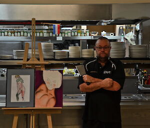 Scotty standing along side with his paintings