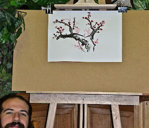 Leon standing along side of this painting of a tree
