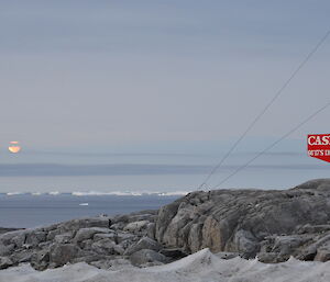 Picture of the moon across Newcombe bay with the Casey sign in the foreground