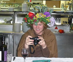Ben dressed in a brown cape and a floral arrangement on his head