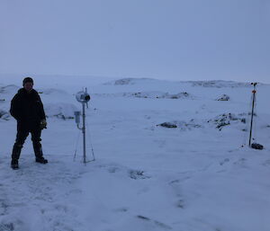 Steve standing with some instruments outside in a snowy terrain