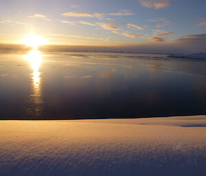 Reflection of the sun on a very still water of Newcombe bay