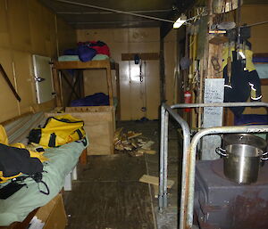 Picture inside the hut, a wood heater and beds