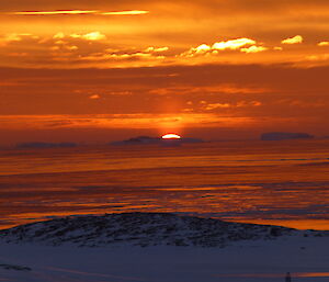 Golden and red sunset over the sea ice