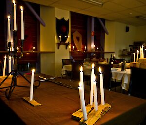 Candle lit room, with medieval battle shields decorated the room. Wooden candle holders and a long sward on the table