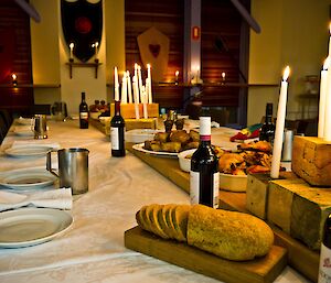 Long candle lit dinning table with delicious spread of food.