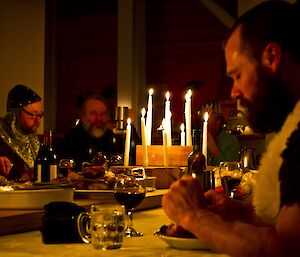 Mick eating in the foreground in a candle lit room