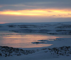 Picture of a frozen Newcombe bay with low clouds with a small break of sunshine