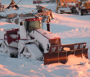 Case quad trac covered in snow after a blizzard.