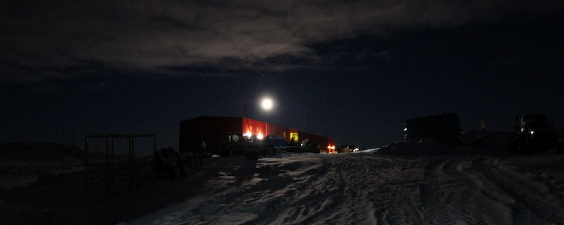 A night shot of Casey’s red shed with some cloud cover and what seems to be a bright moon over the Red Shed