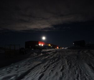 A night shot of Casey’s red shed with some cloud cover and what seems to be a bright moon over the Red Shed