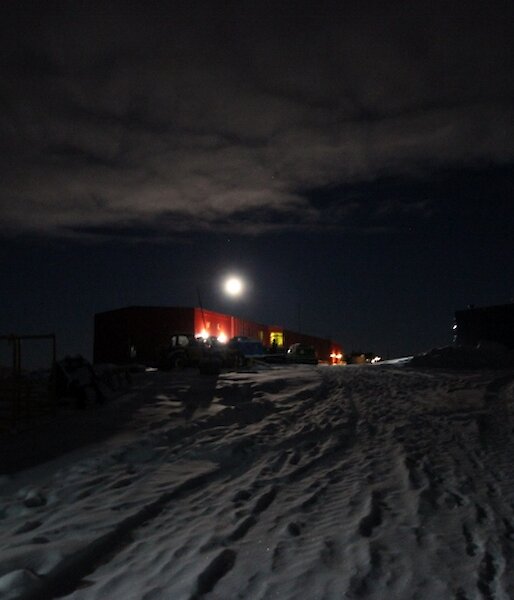 A night shot of Casey’s red shed with some cloud cover and what seems to be a bright moon over the Red Shed