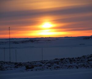 A sunset with think midldle level cloud extending the sun rays like a pillar