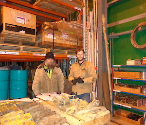 Mark and Aaron standing in front of the warehouse racks