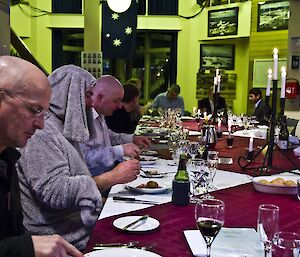 A profile picture down a long dinner table with expeditioners at the table