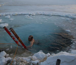 Matty in the cold water about to climb out using the ladder