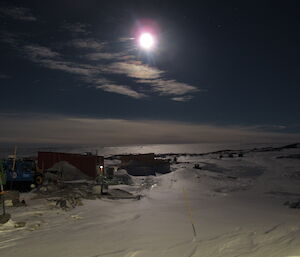 A night shot of a bright and large moon over the buildings of Casey