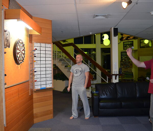 Allan throwing darts while lee watches