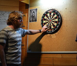 Tim taking his darts off the board
