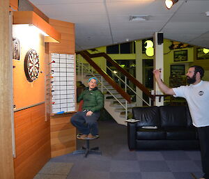 Leon throwing darts while Chad scores