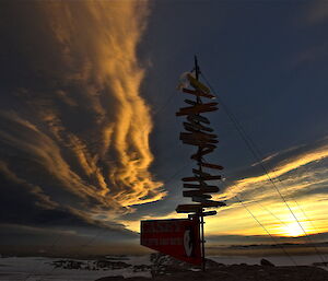 Dark layered clouds over the Casey direction sign post