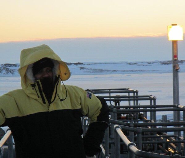 Abrar posing in the upper fuel farm over looking the frozen sea ice in the background