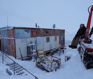 Matty sitting at the back of a Hagg with snow cover Wilkes Hut