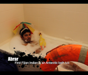Abrar wearing an umbrella hat in a bathtub full of bubbles
