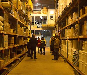 Group of people gathered in between the tall racks