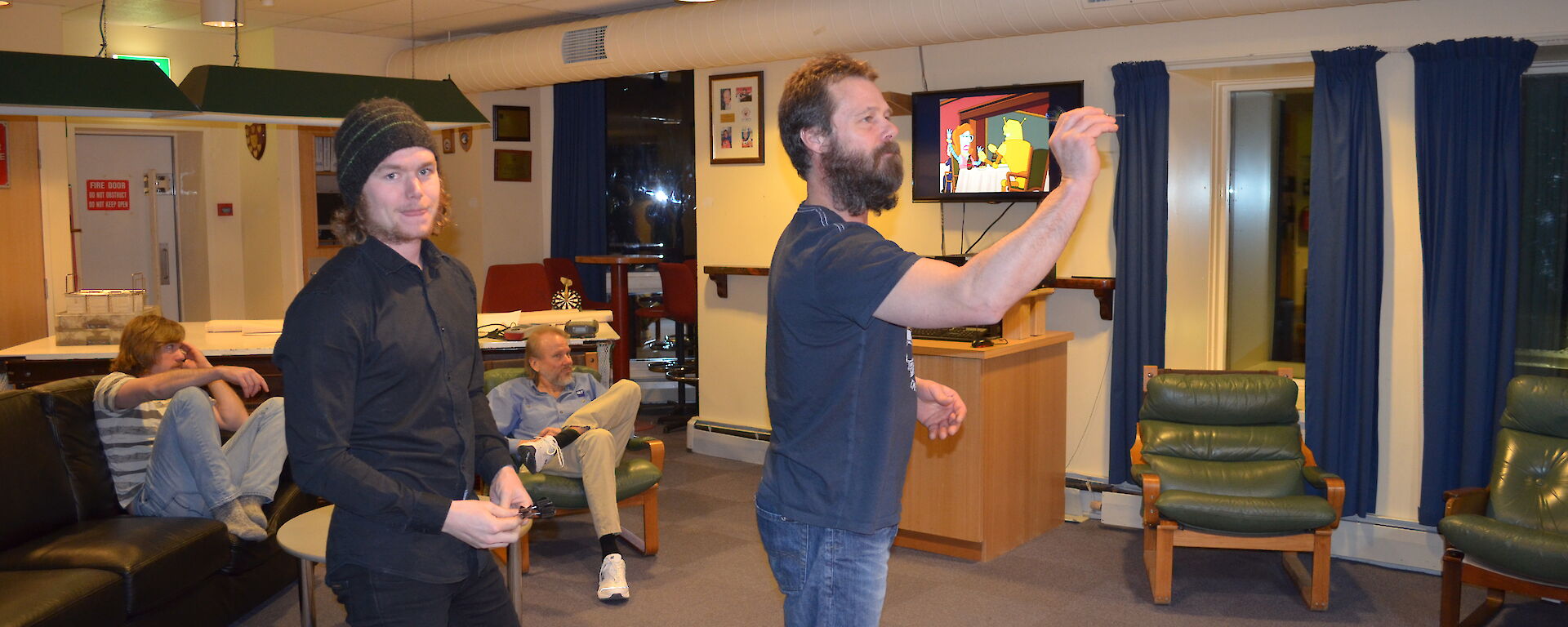 Mick W taking a his shot of darts while Ben looks on