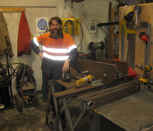 Andy standing in front of his workshop desk