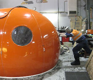 Matt pushing an orange melon shaped refuge hut