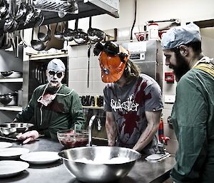 The Doctor Chad and Leon in zombie doctor dress up while Ben in a blood stained shirt busy in the kitchen