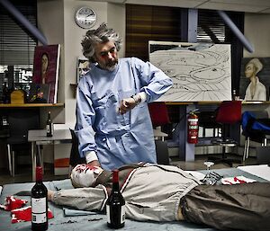 Allan in a Zombie doctors outfit checking vitals on a dummy