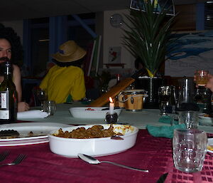 People with wigs eating a traditional Jamaican dinner