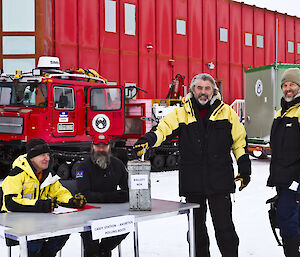 Allan and a number of expeditioners in front of the red shed and a hagg