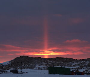 Sunset in a cloudy day with a Sun ray pillar