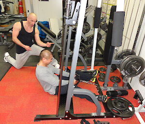 Michael on the weighted row machine while Lee looks on