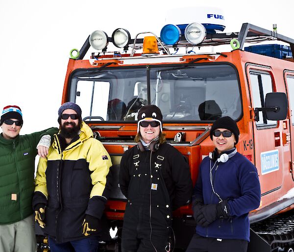 Chad, Leon, Ben and Michael standing in front of an orange Hagg