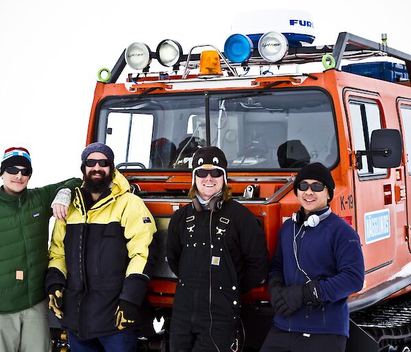 Chad, Leon, Ben and Michael standing in front of an orange Hagg