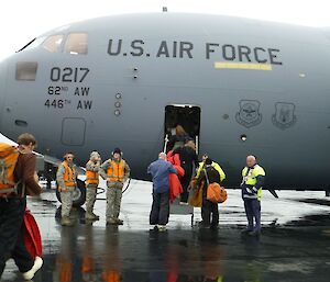 Gerry and crew boarding a large grey military aircraft